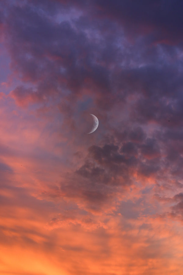 Moody purple and orange clouds with moon for Zodiaque Moon monthly horoscopes
